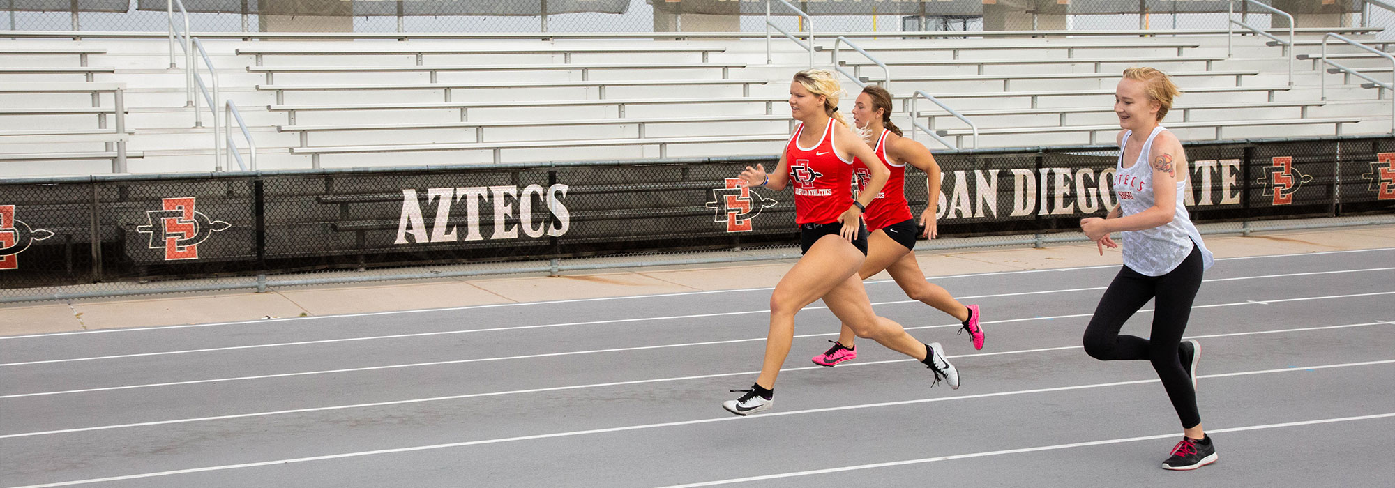 Three Track and Field members running on aztrack