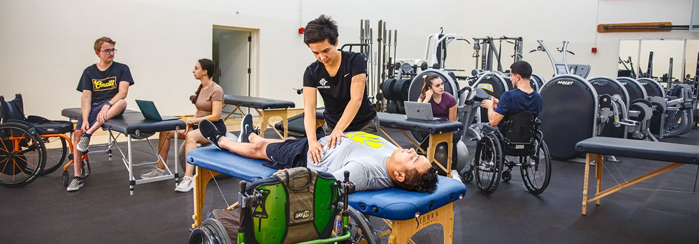 Several Adapted Athletics team members working with Physical Therapist