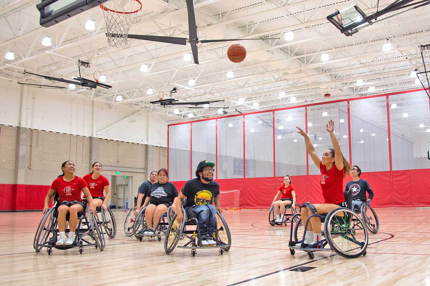 Adapted Athletics Wheelchair basketball game - woman throwing basketball into a hoop