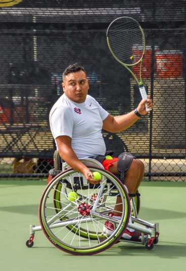 Manny Gomez preparing a serve at the wheelchair tennis invitational.