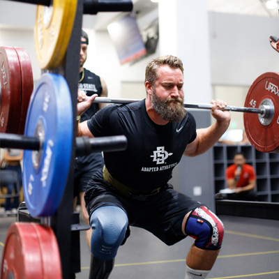 An athlete with a prosthetic leg performs a 180lb squat lift.