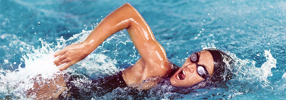 Woman swimming in pool using breast stroke