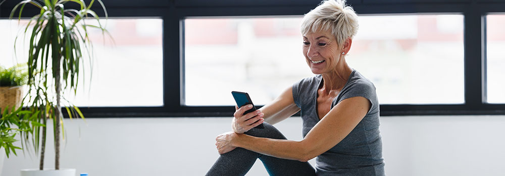 Older woman in fitness gear looking on her phone
