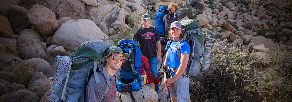 Four students on a long hike at Joshua Tree 