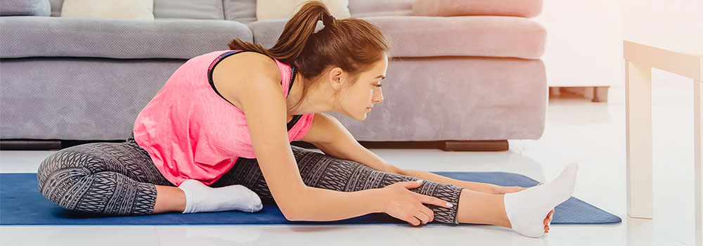 Woman stretching legs on a yoga mat