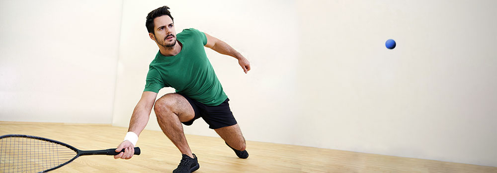 Man hitting ball with racquetball racket