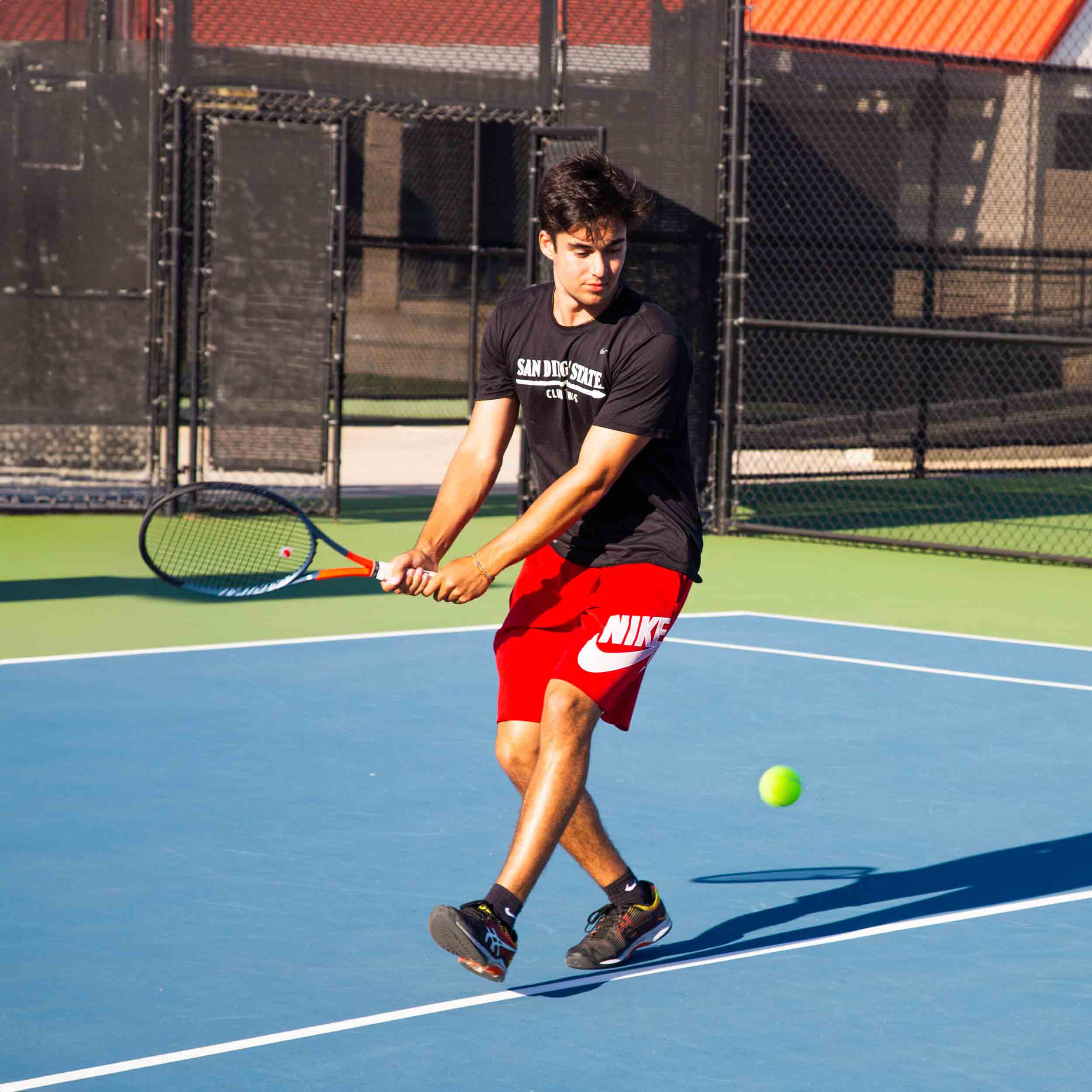 Male Club Tennis member with tennis racquet getting ready to hit a tennis ball