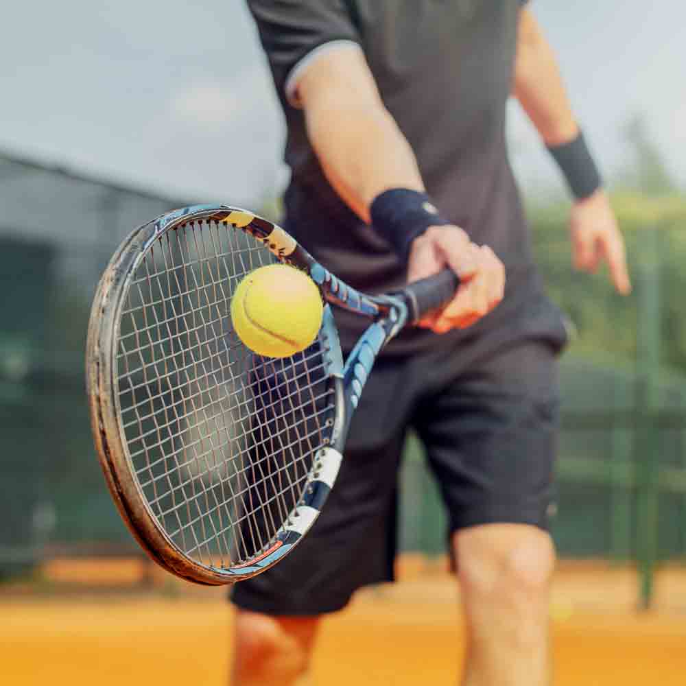 A tennis player about to hit back the ball with a racquet 