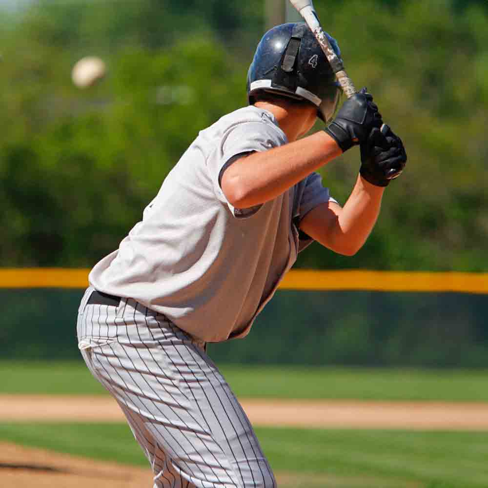 Baseball player about to hit the baseball with the bat