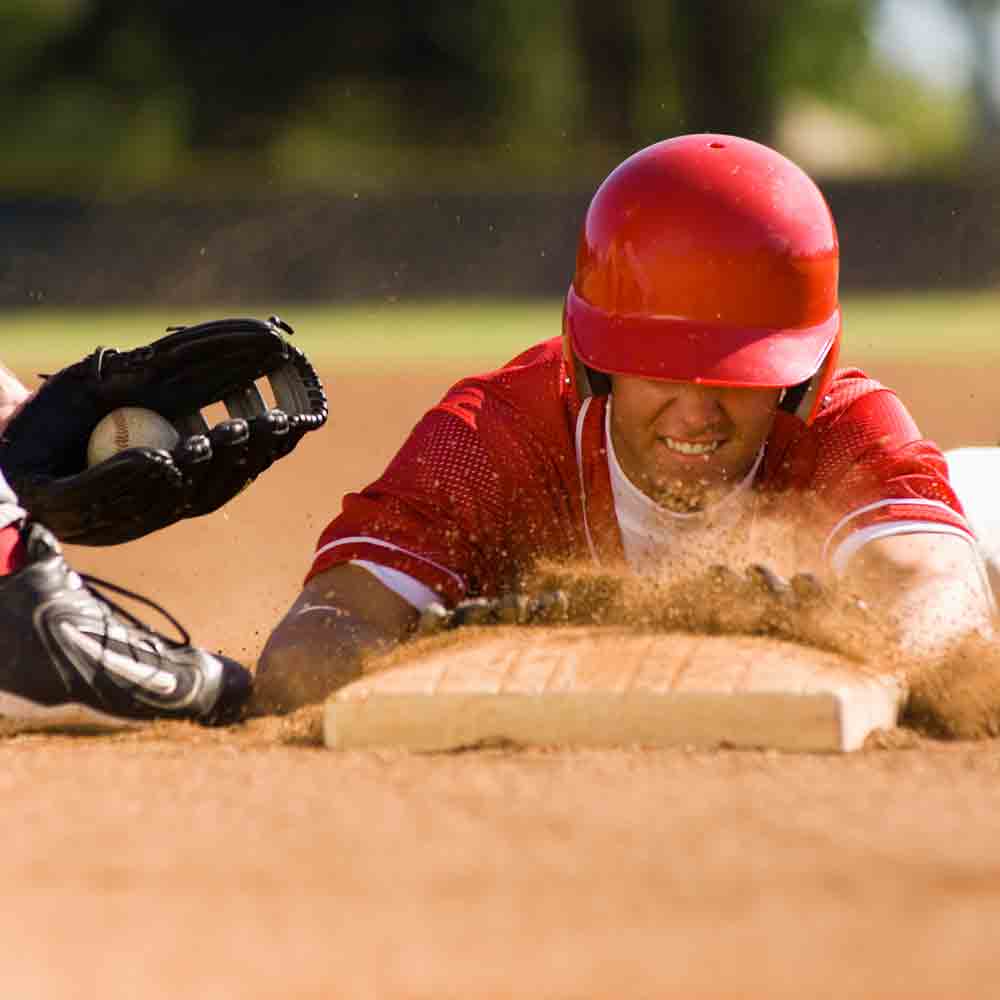 A baseball player sliding into the base while the opponent with ball trying to out him