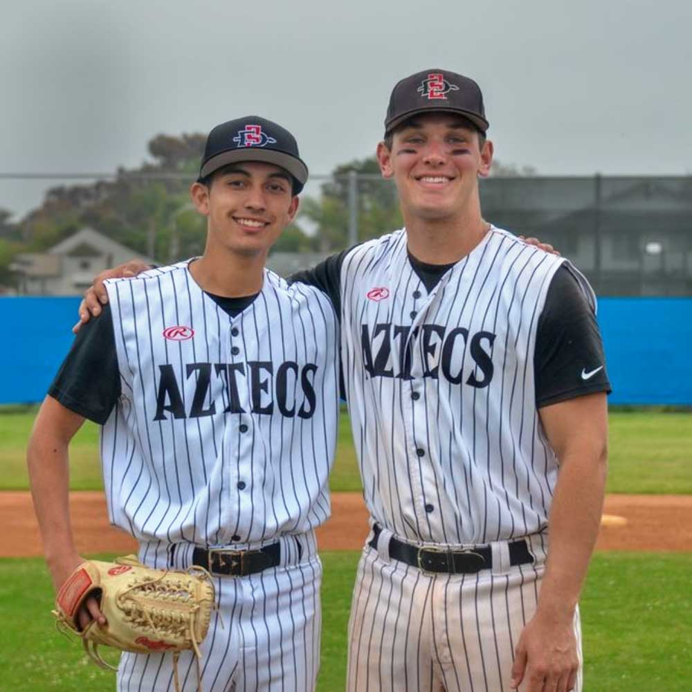 Two smiling baseball club members after a game