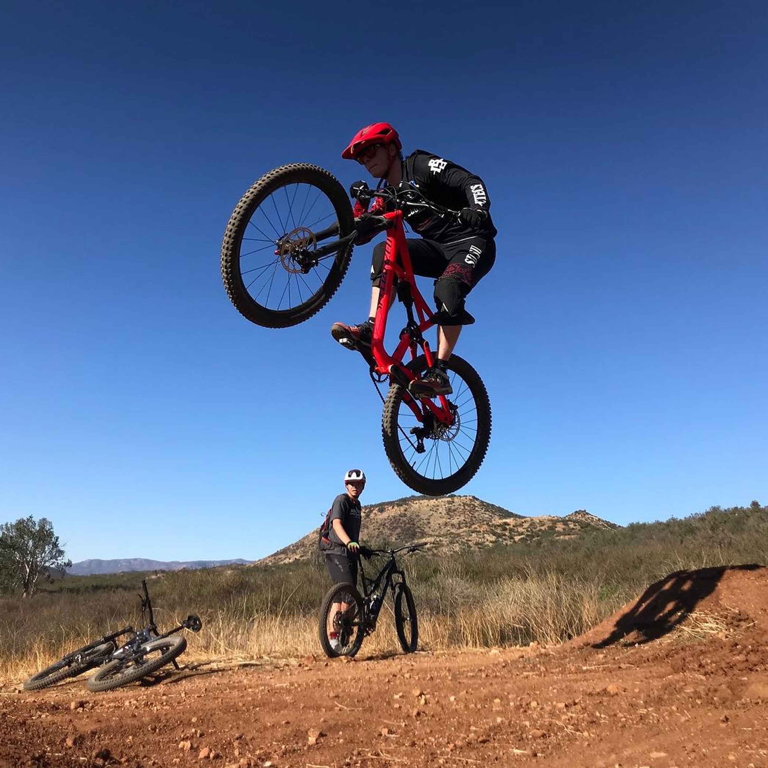 Cycling member making a jump on a mountain bike