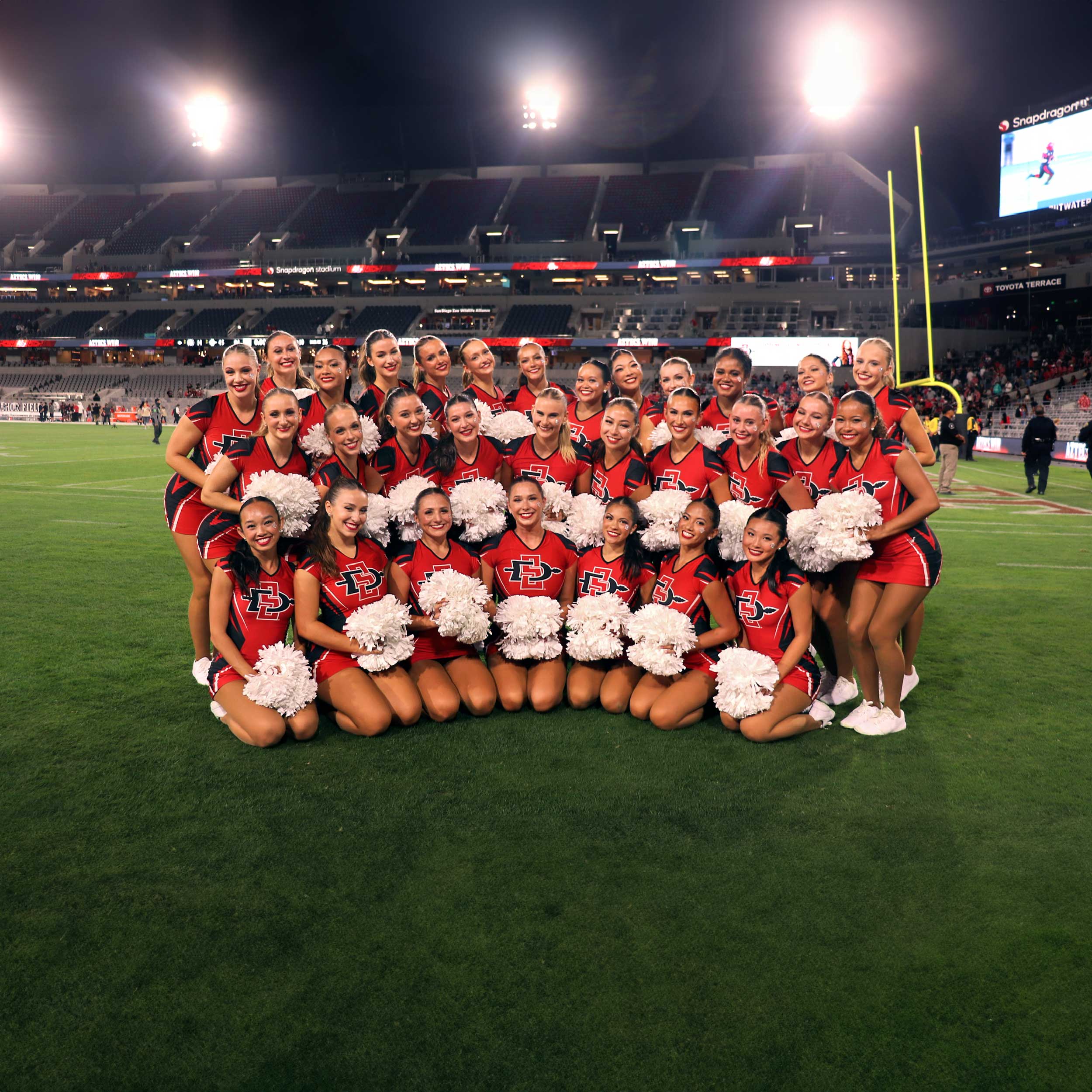 Group photo of SDSU Dance Team on the field of Snapdragon stadium