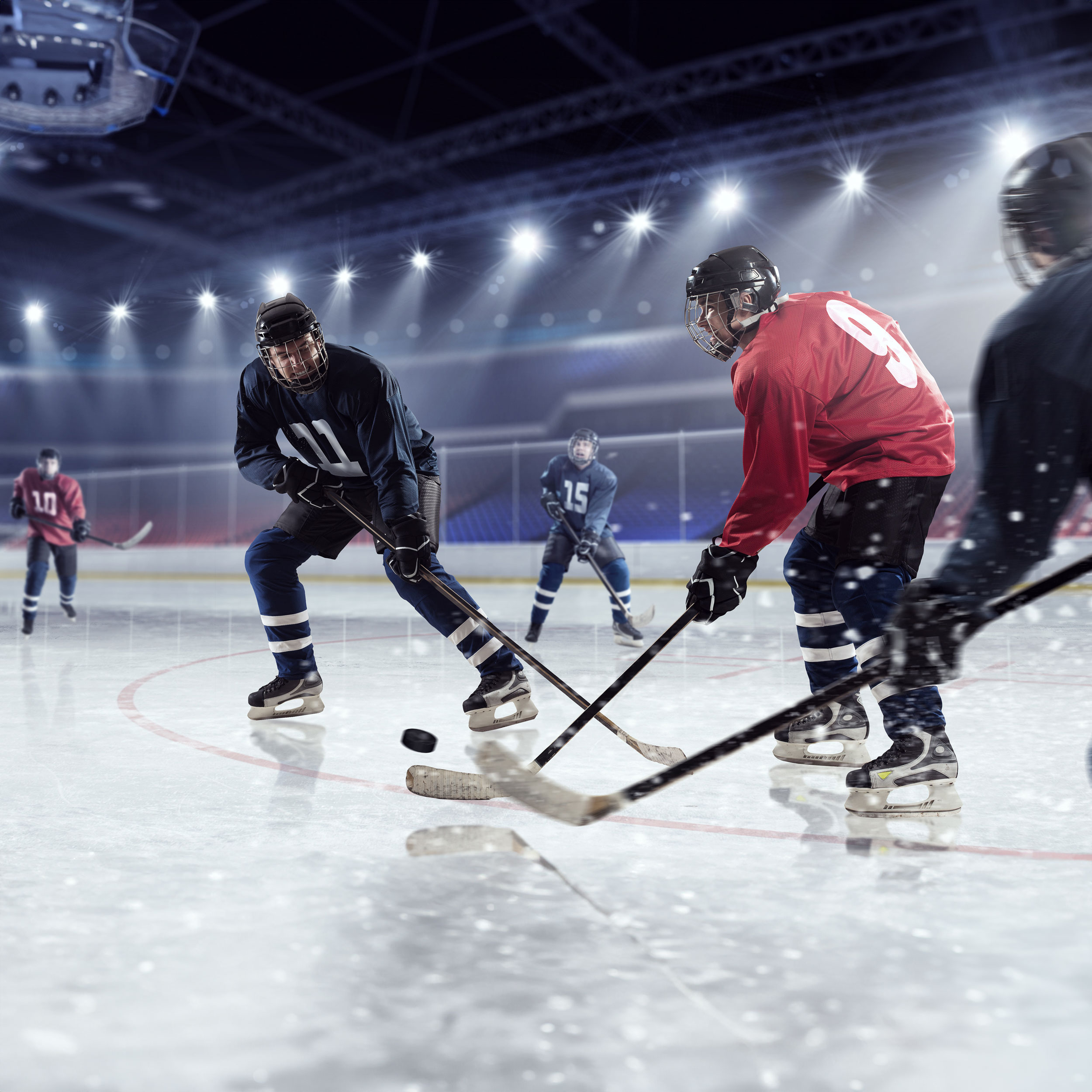 Hockey players skating on an ice rink, fiercely competing for the puck.