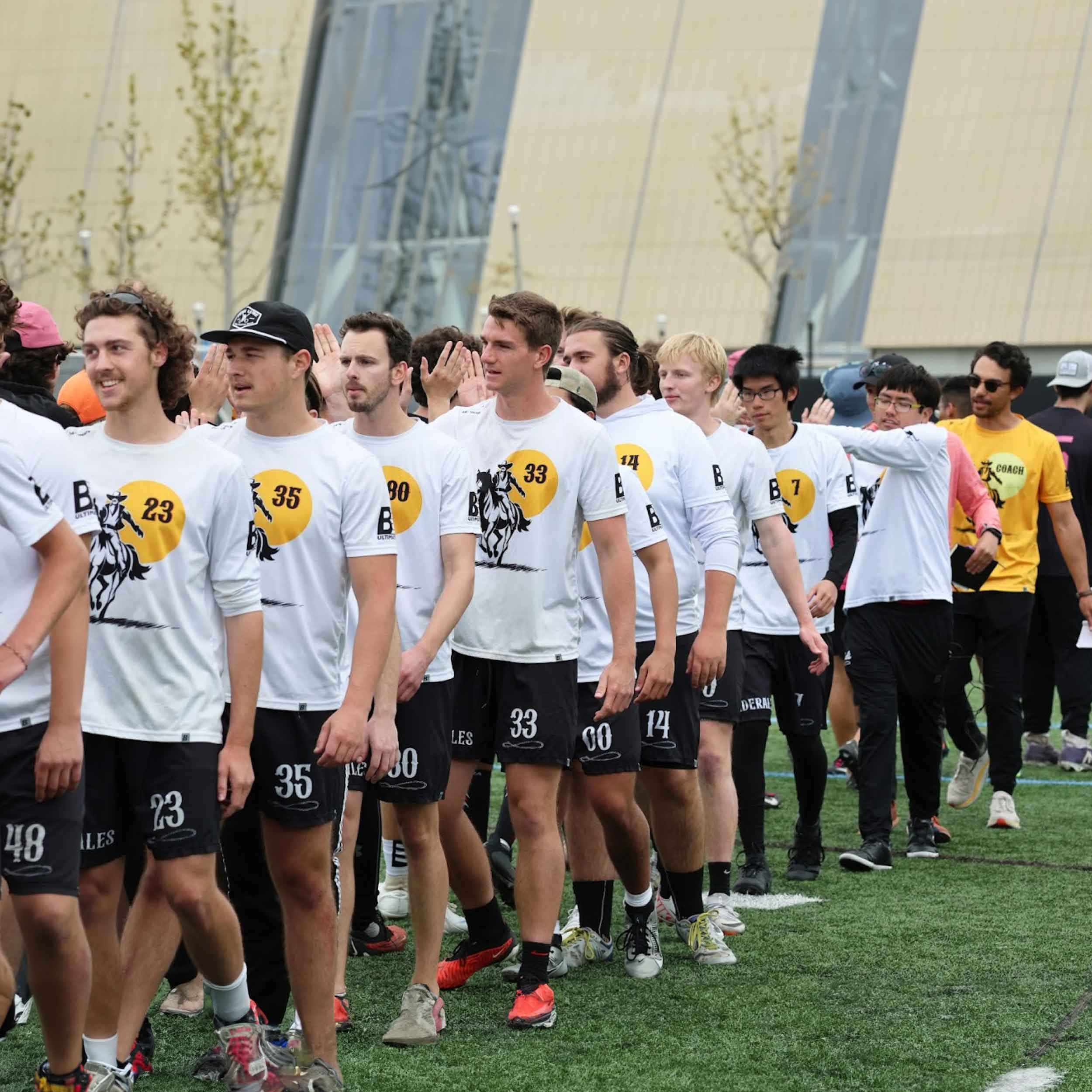 A row of SDSU Men's Ultimate players high fiving opponent team.