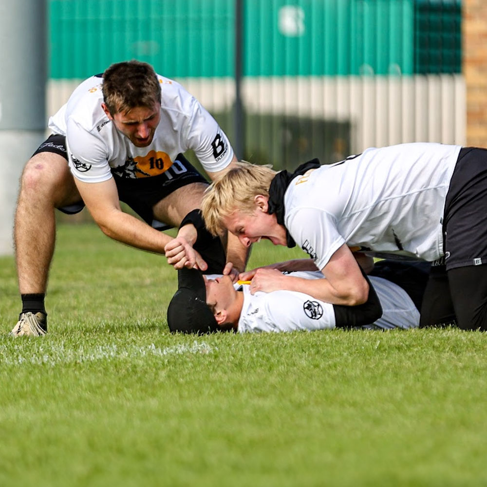 SDSU Men's Ultimate club members cheering a teammate laid out on the grass