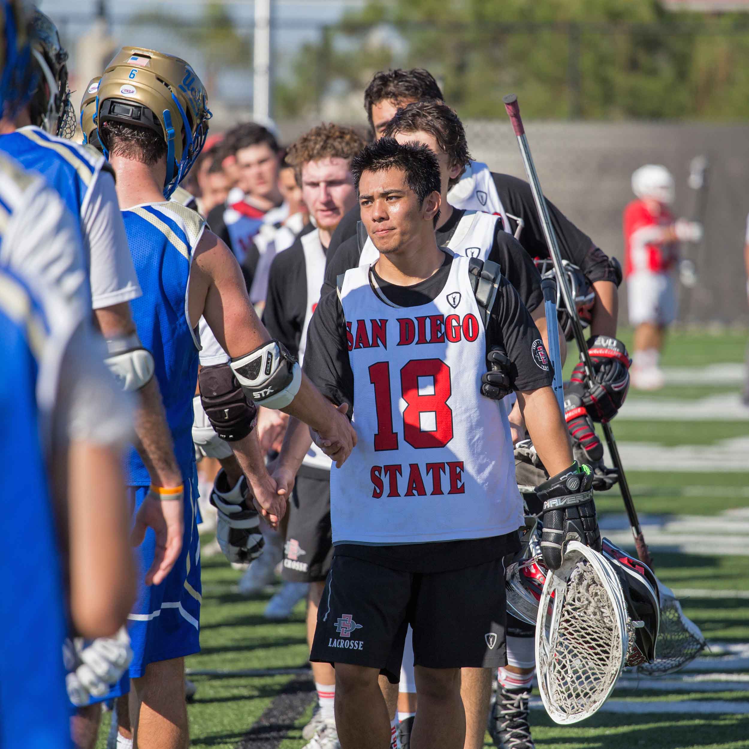 Men's Lacrosse Team members shaking hands with opponent team