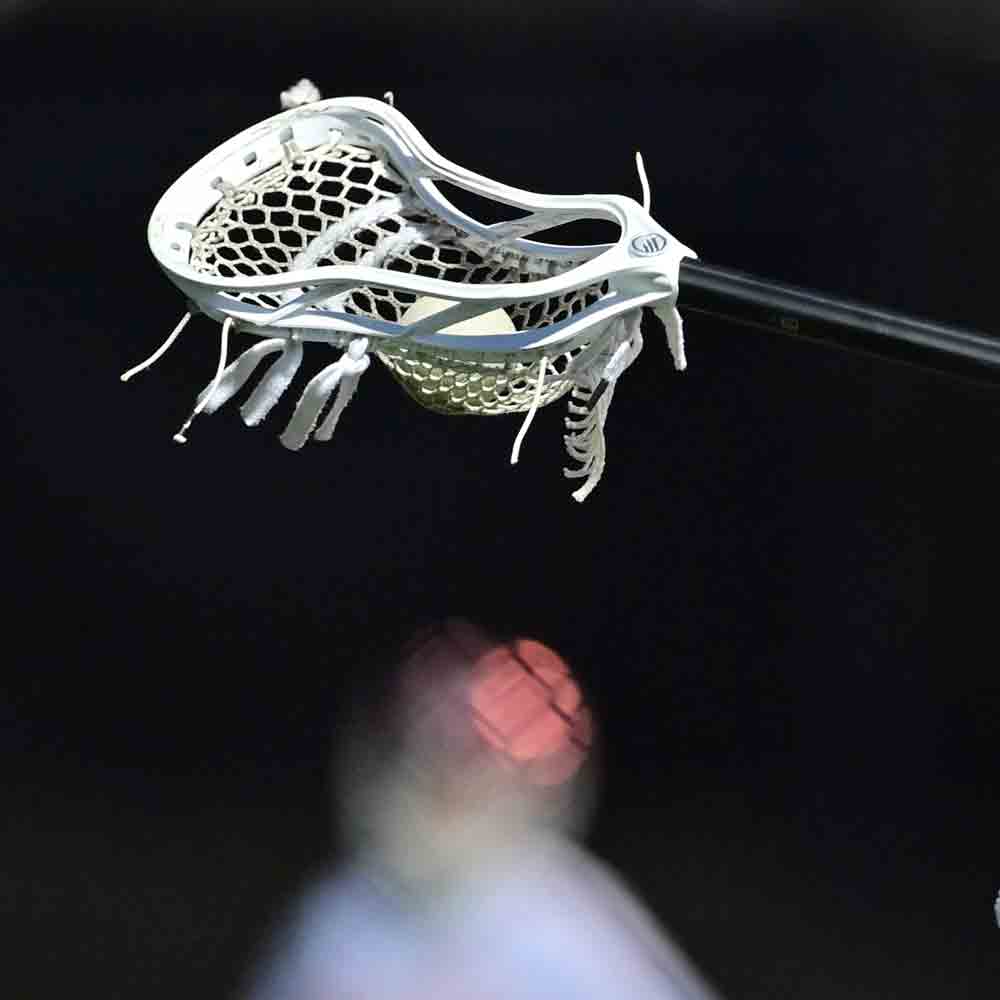 Lacrosse stick against a dark background