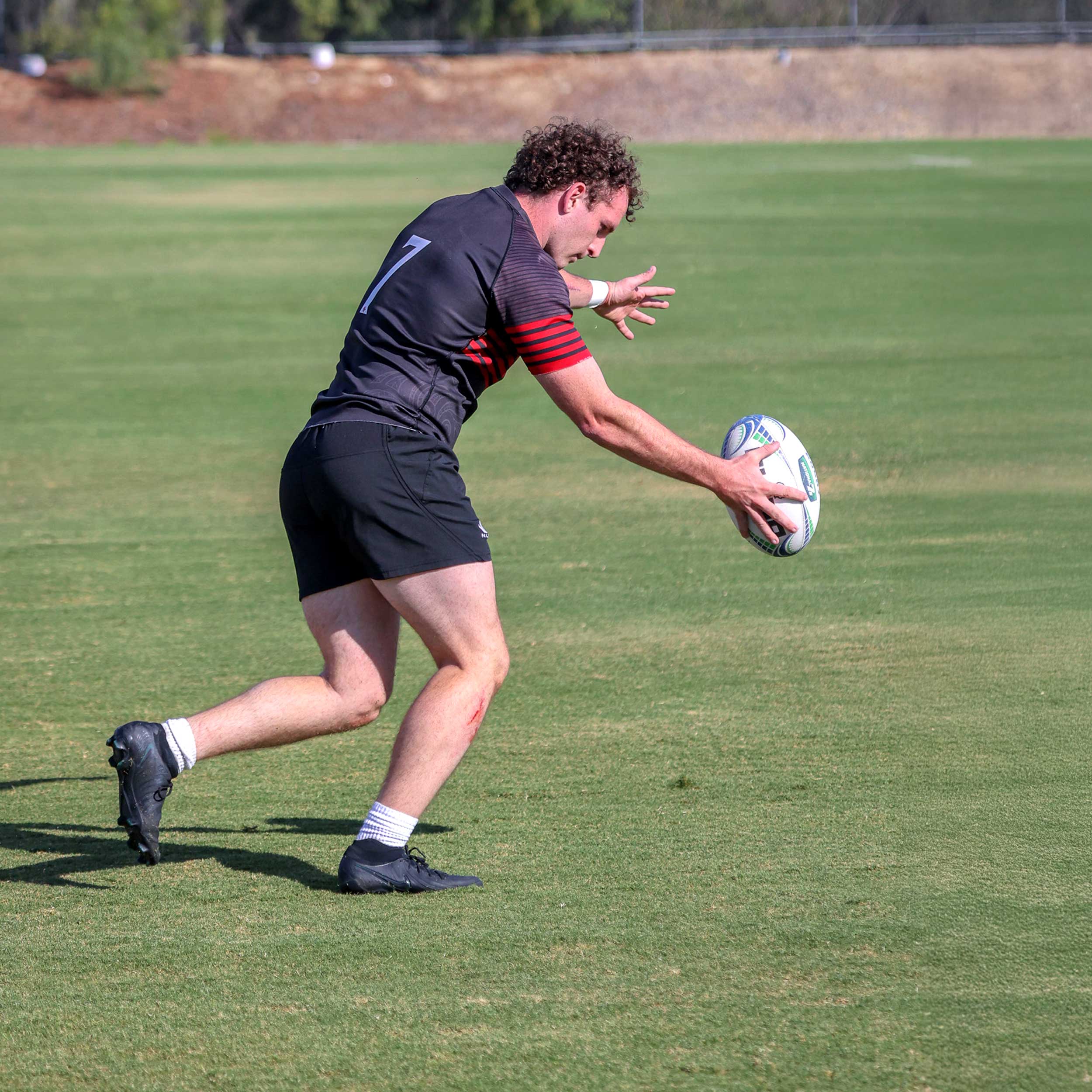 Men's Rugby player about to kick the ball
