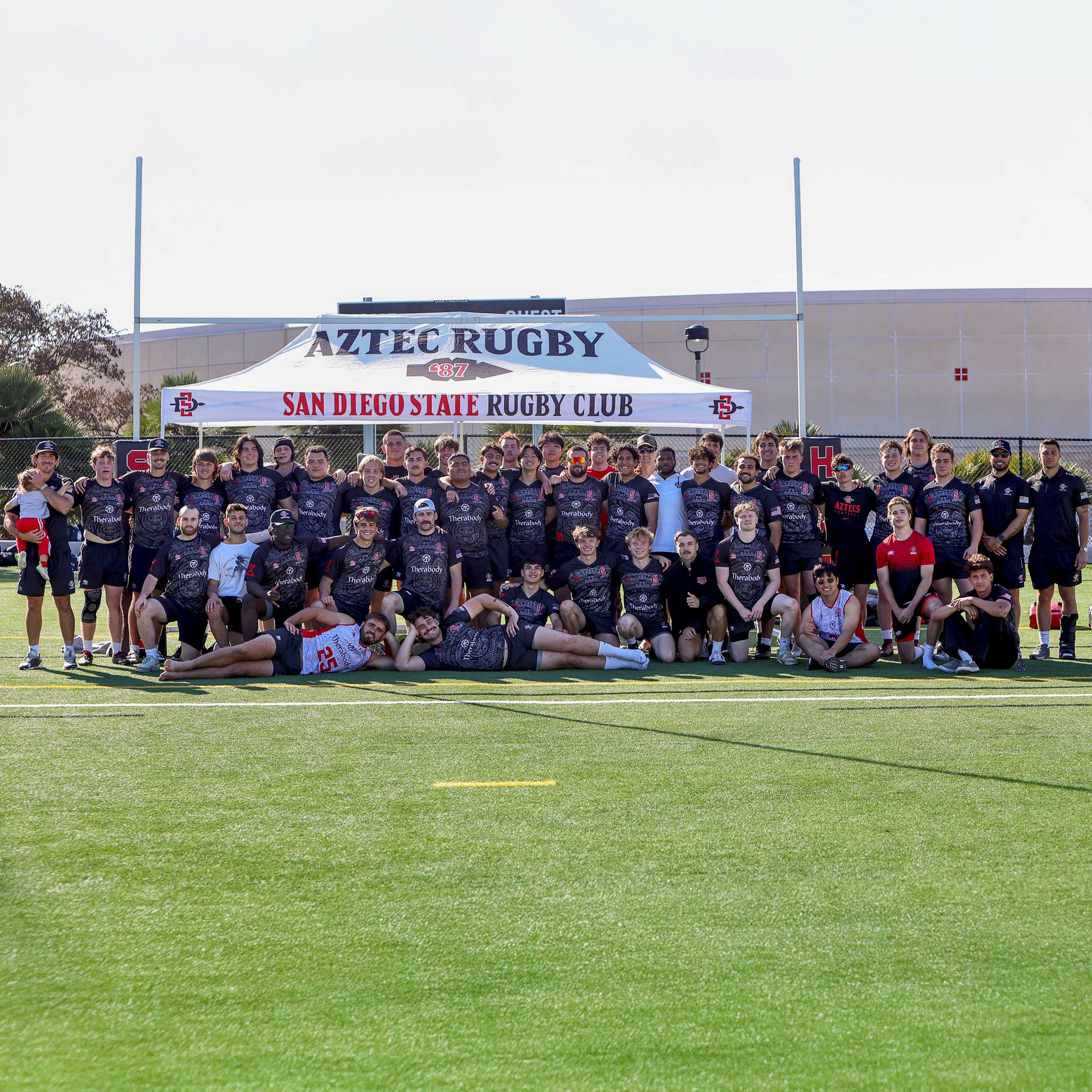 Men's Rugby Team posing on a grass field