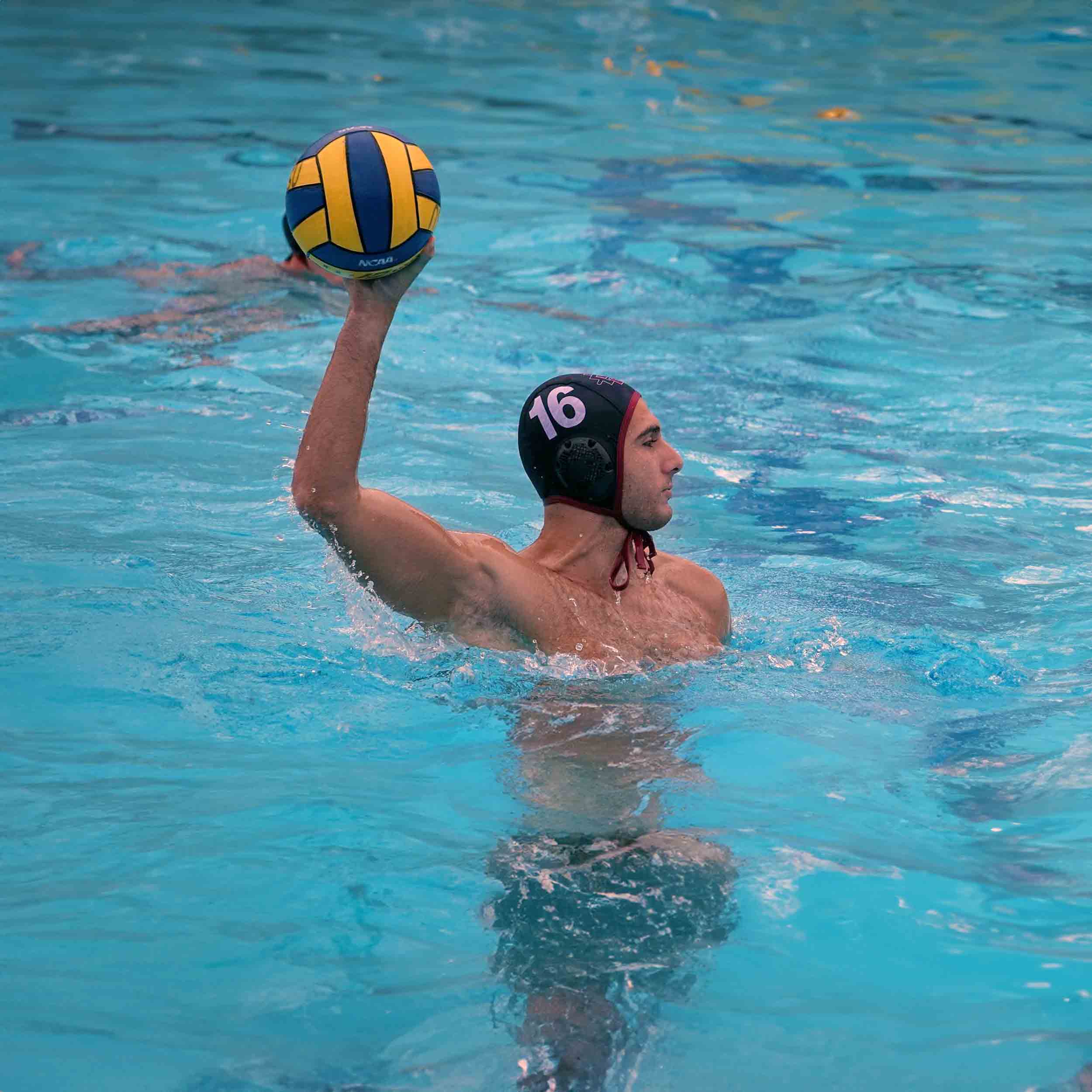 Men's Water Polo Player in the pool getting ready to throw the ball