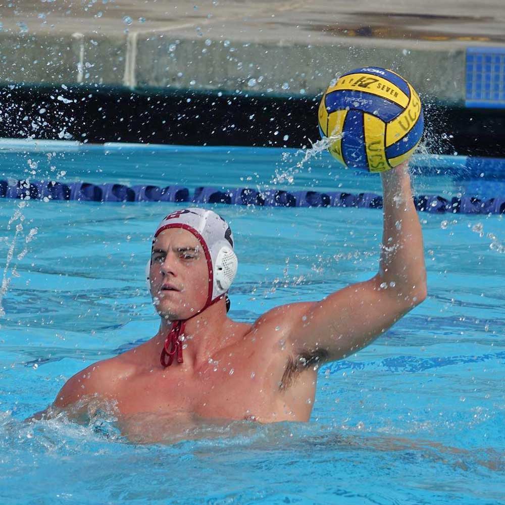 Men's water polo member getting ready to throw the ball inside the pool