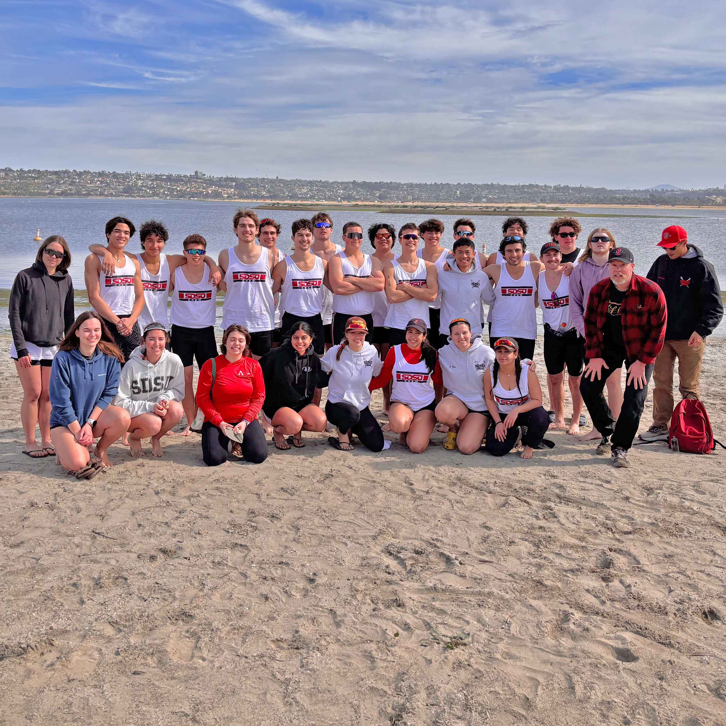 Group photo of the Aztec Rowing team members at the beach
