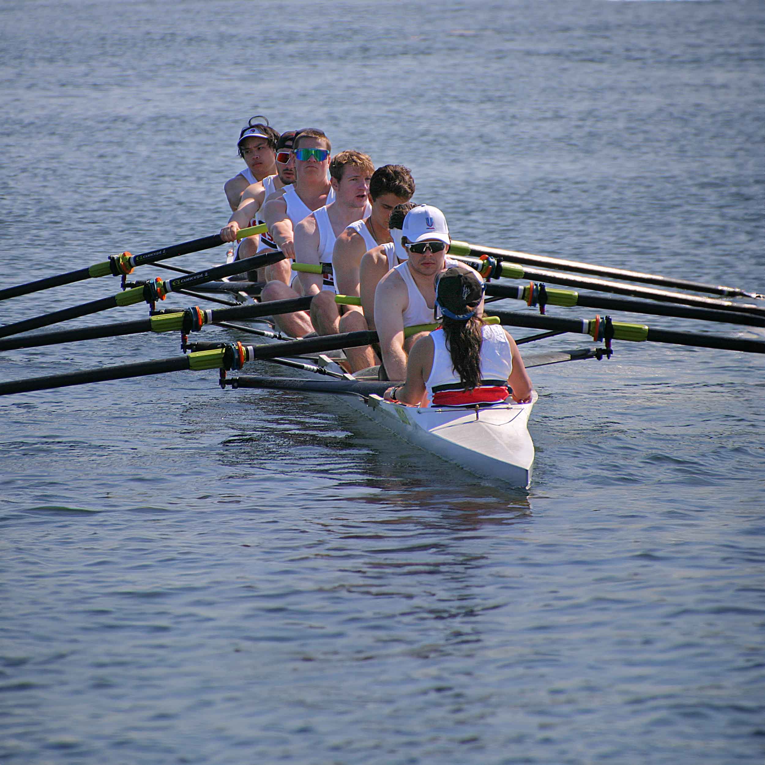 Crew members in boat pushing off the dock