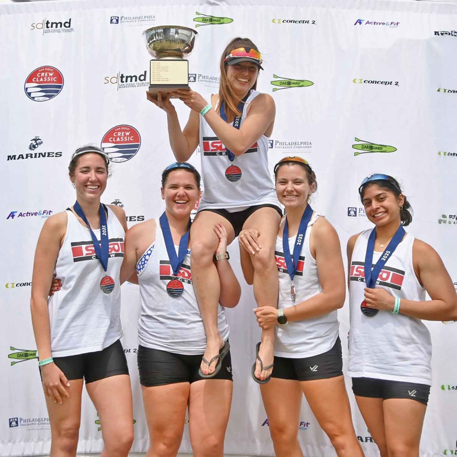 Rowers paddling together in a boat on the water.
