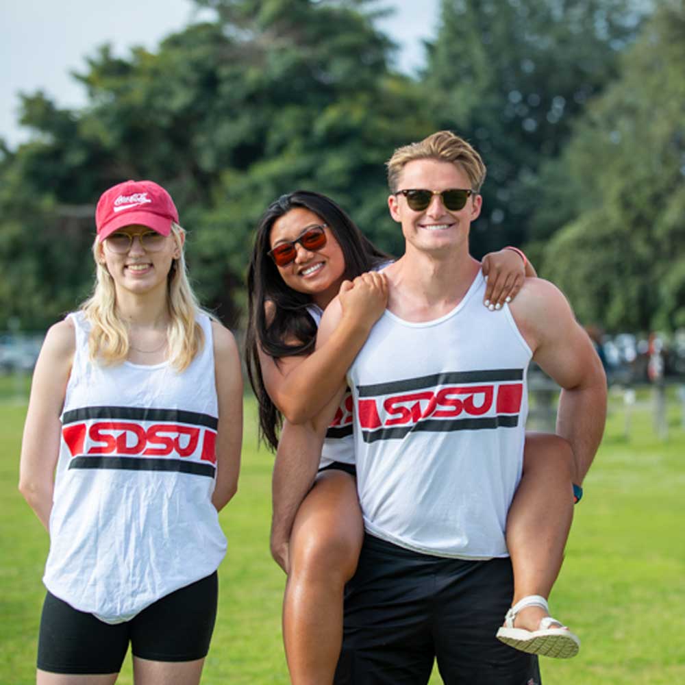 Three smiling rowing club members in the park