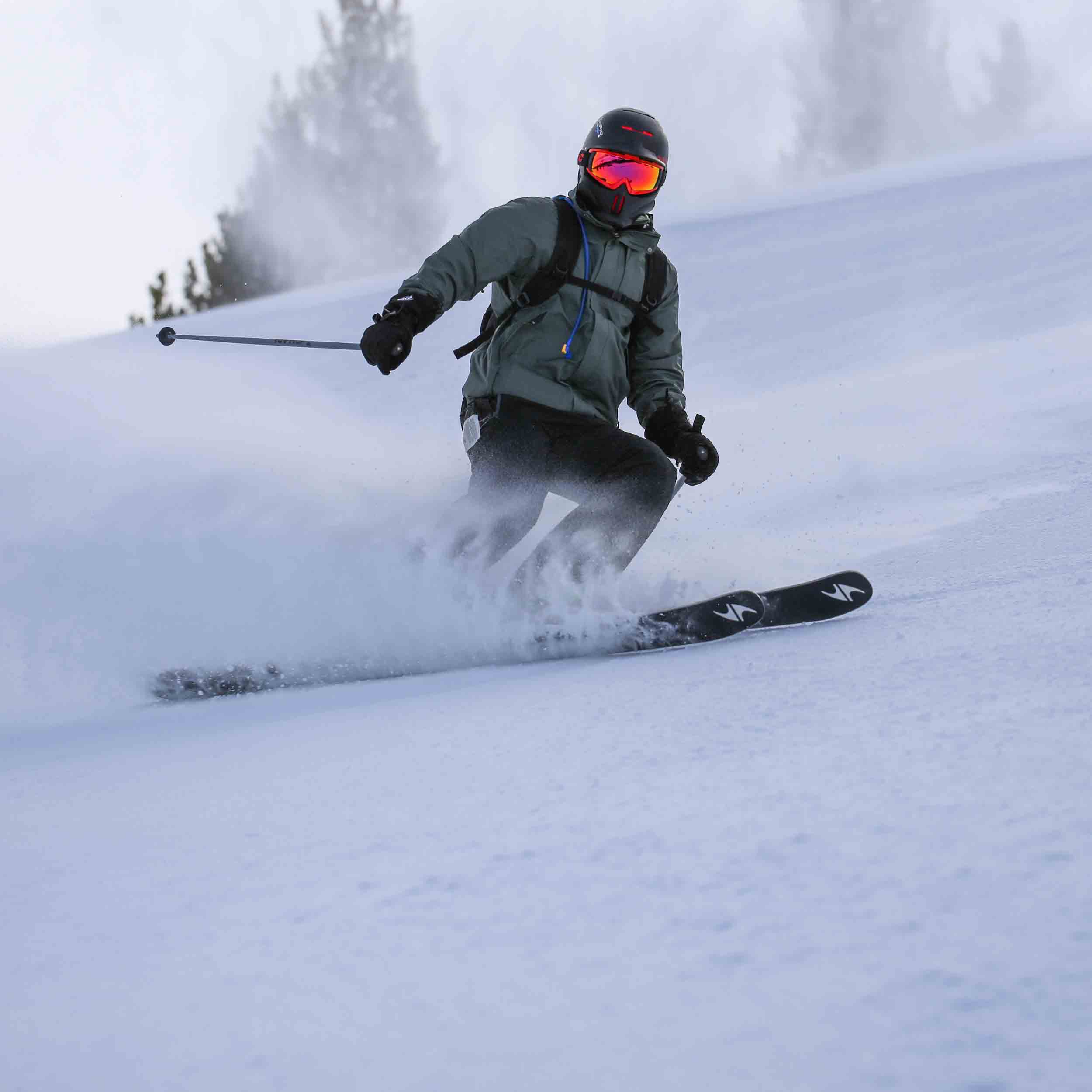 Ski club team member skiing down a montain in snow