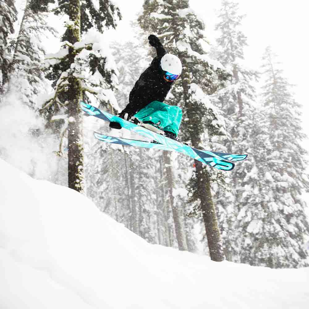 A snowboarder soaring through the air above a snowy slope, showcasing their skills and enjoying the winter thrill.