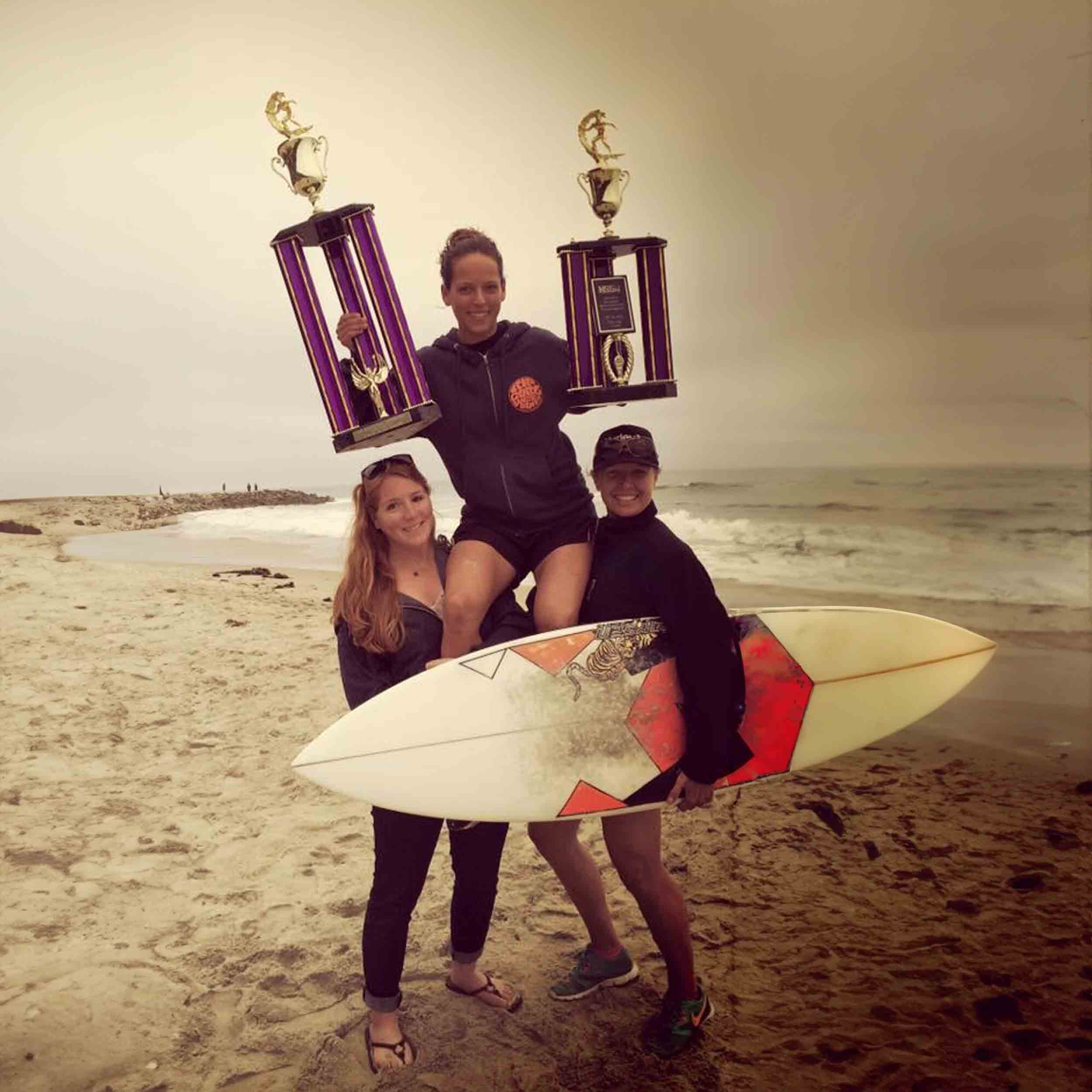 3 Surf Club members showing off their trophies at the beach