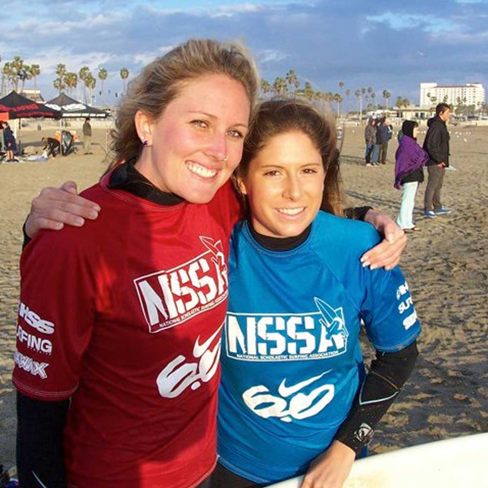 Two smiling surf club members on the beach  at a competition event 