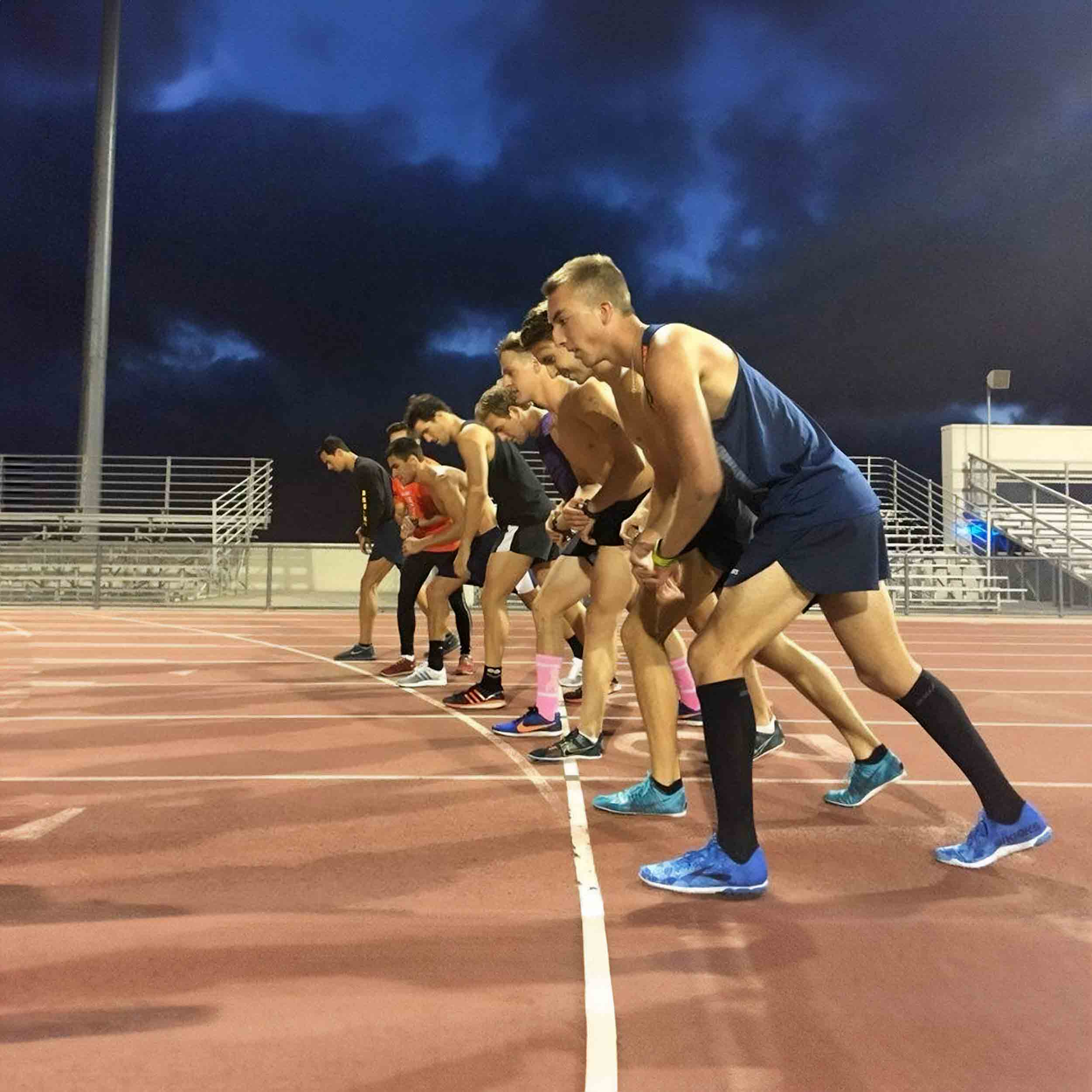 A row of triathlon members on the track field ready to run