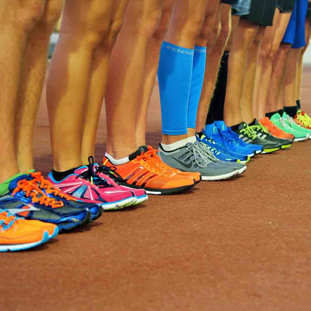 Row of team member legs in running shoes