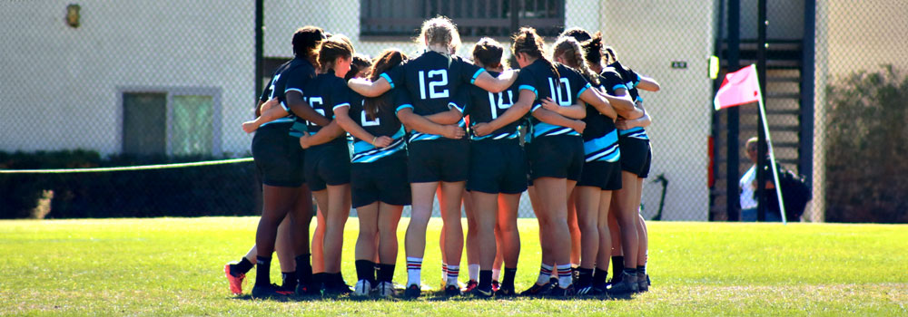 Women's Rugby team in a huddle