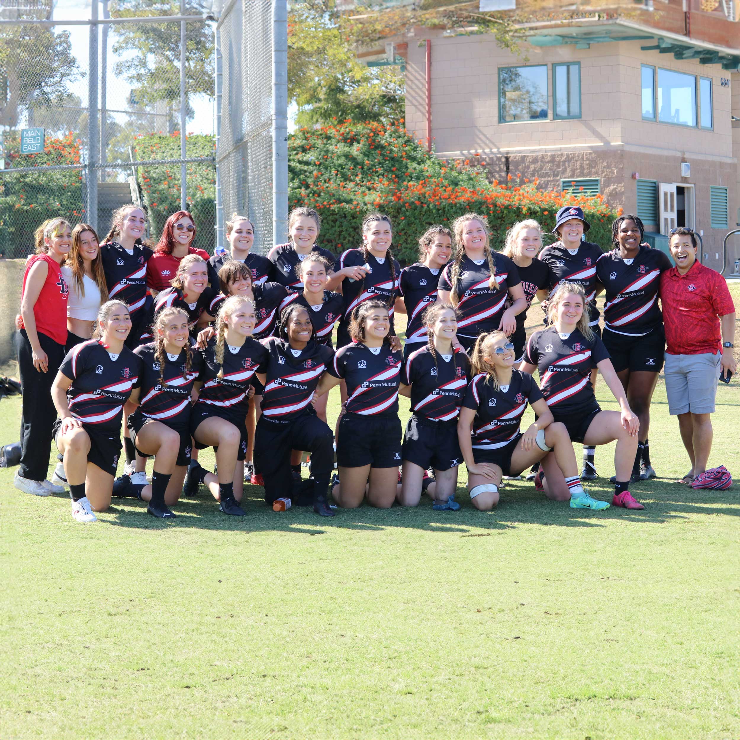 Group photo of the Women's Rugby team members on the field