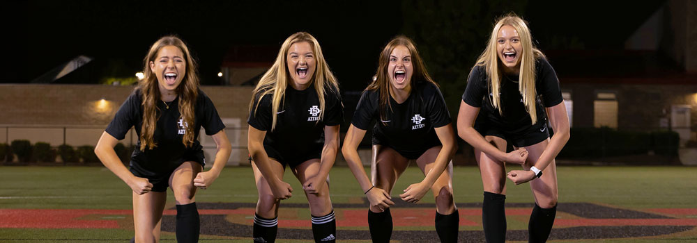 Four Women's Soccer Club Members on a field