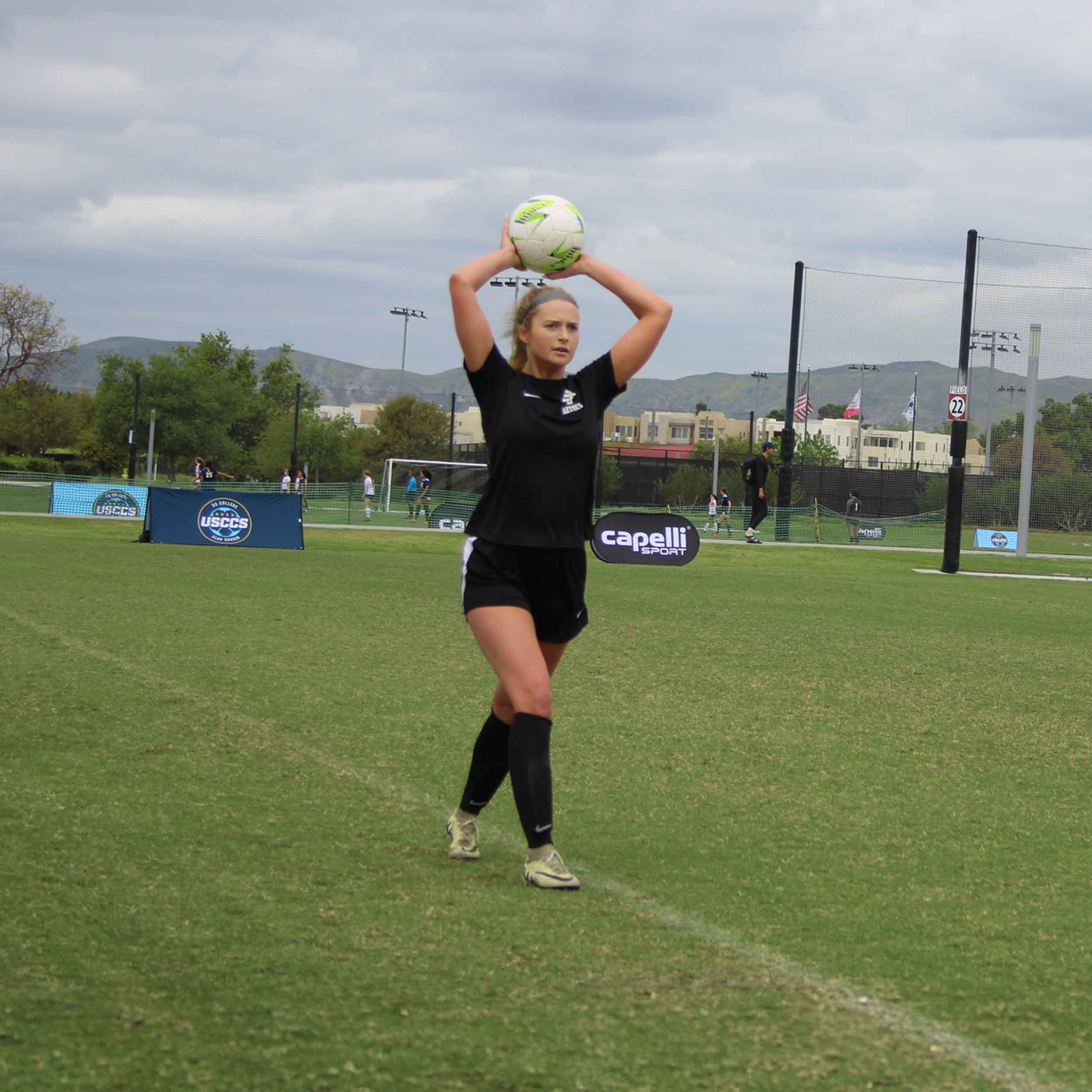 SDSU Women's Player in the midst of throwing soccer ball over her head