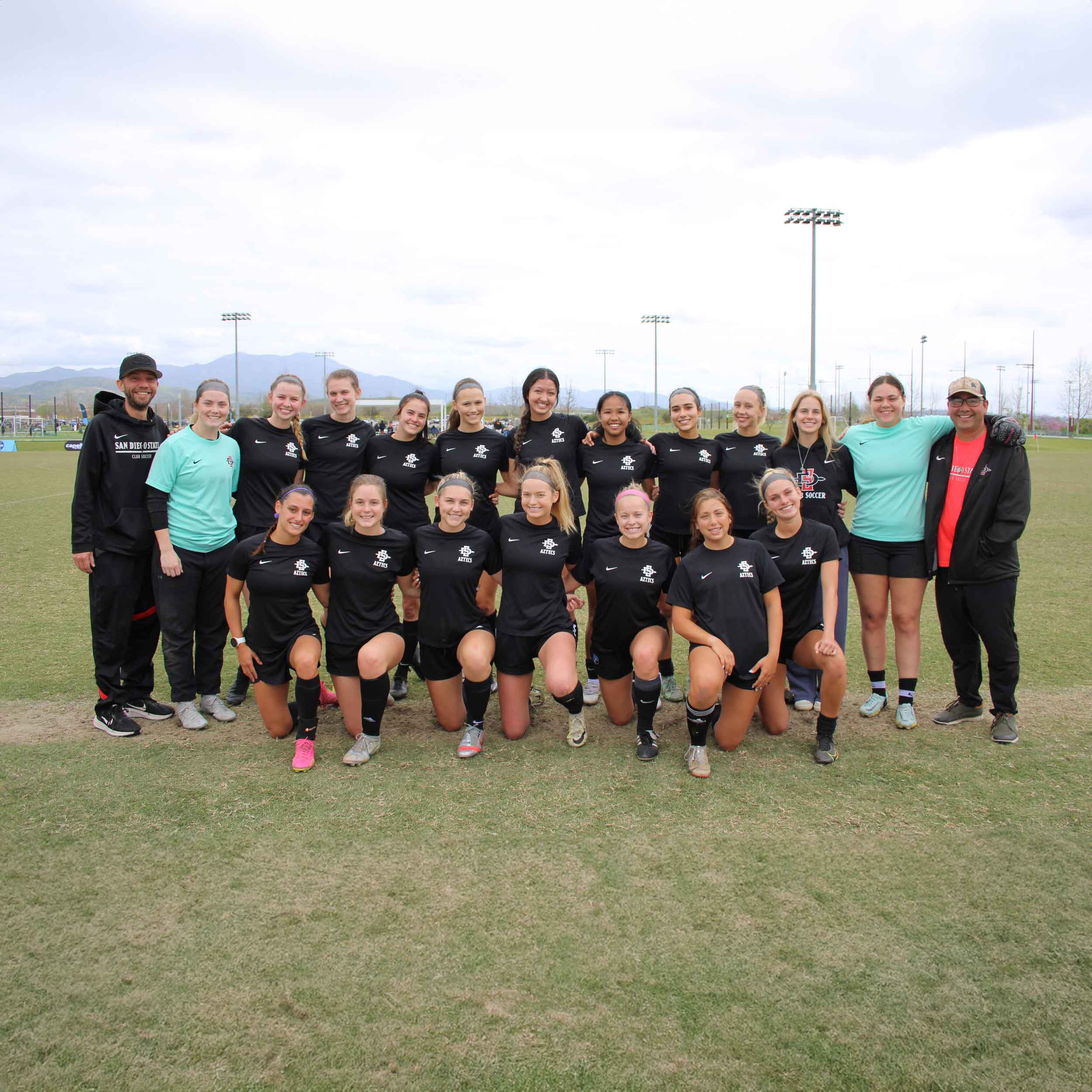 Group photo of the women's soccer club team on the soccer field