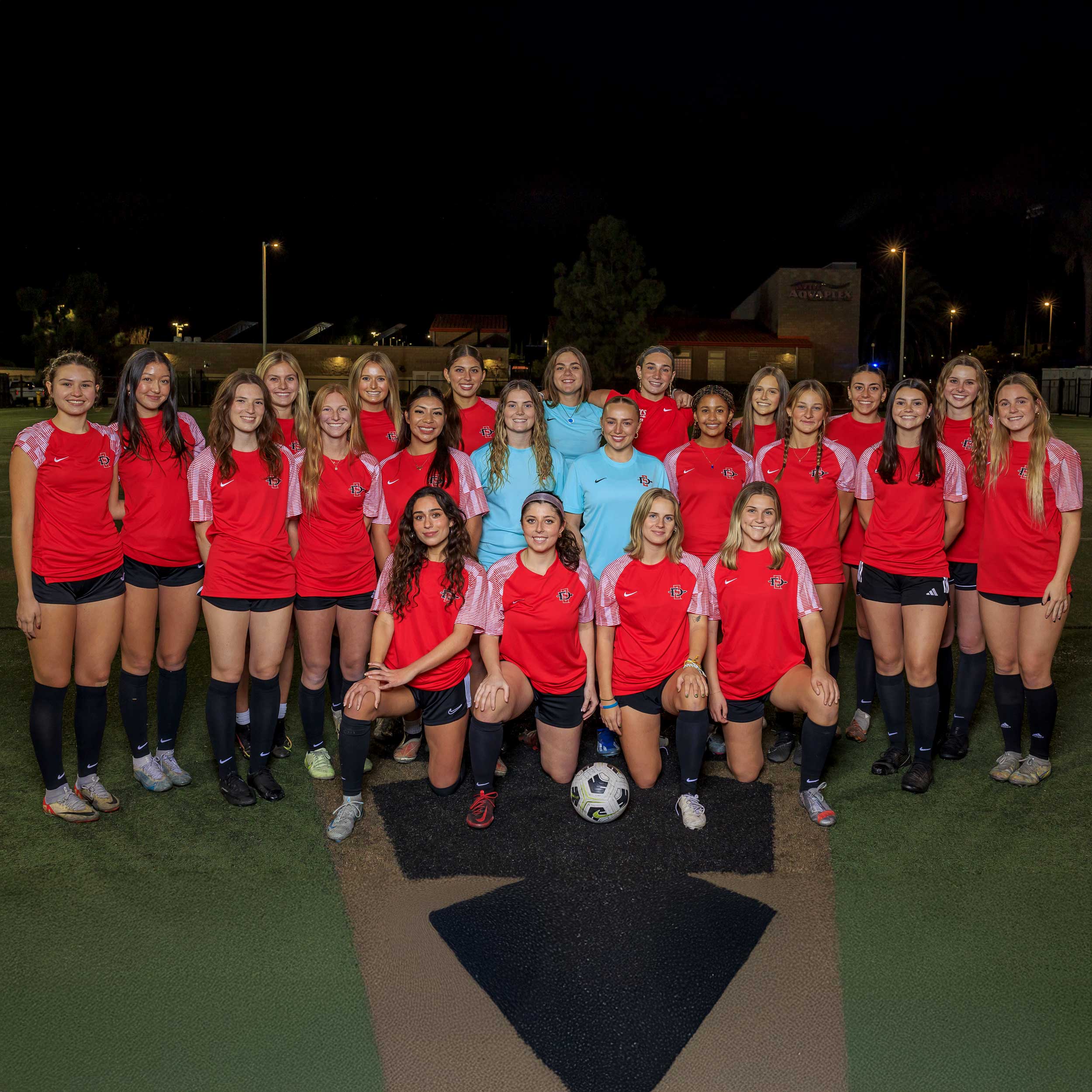 Group photo of the women's soccer club team on the soccer field