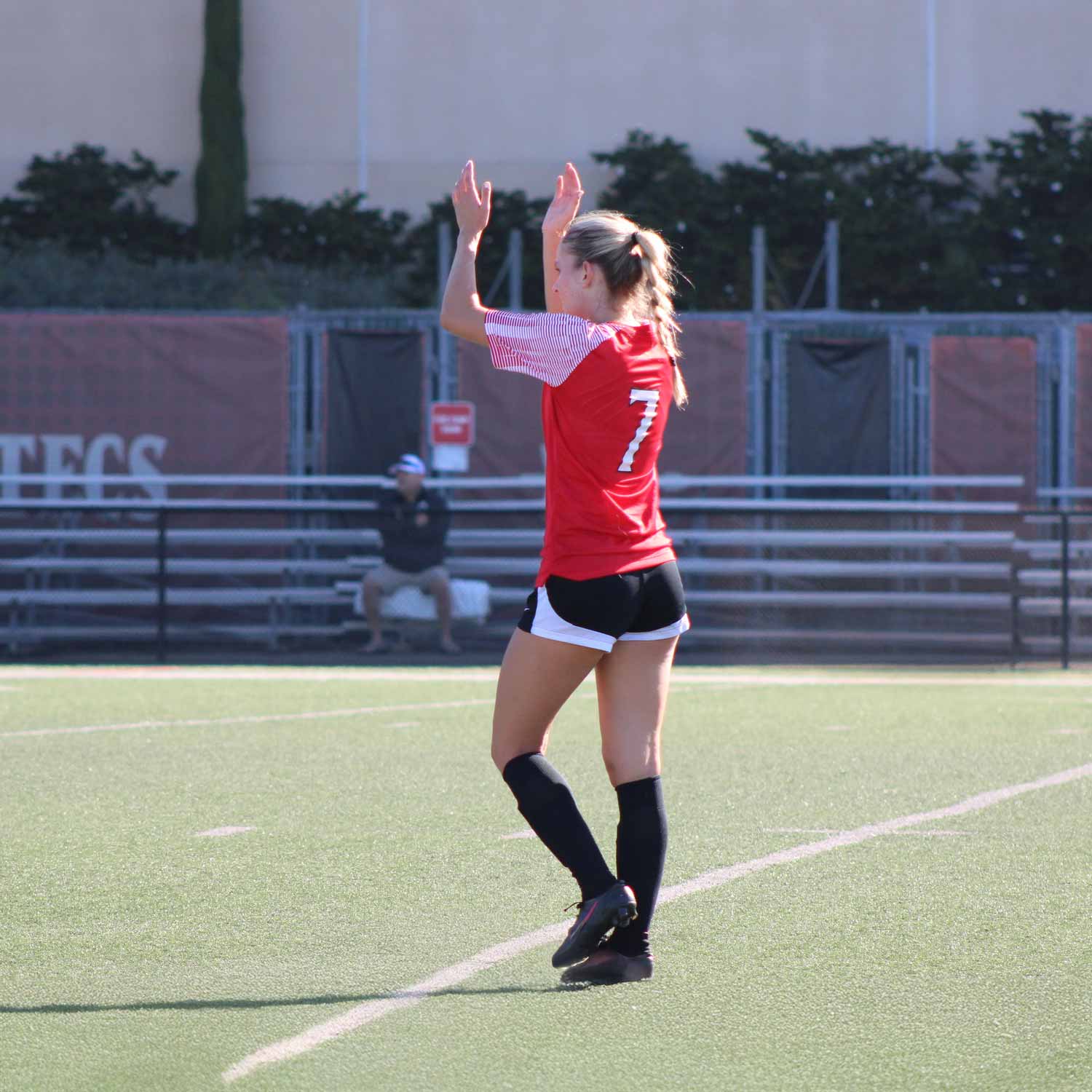 Player walking on grass field clapping during the game