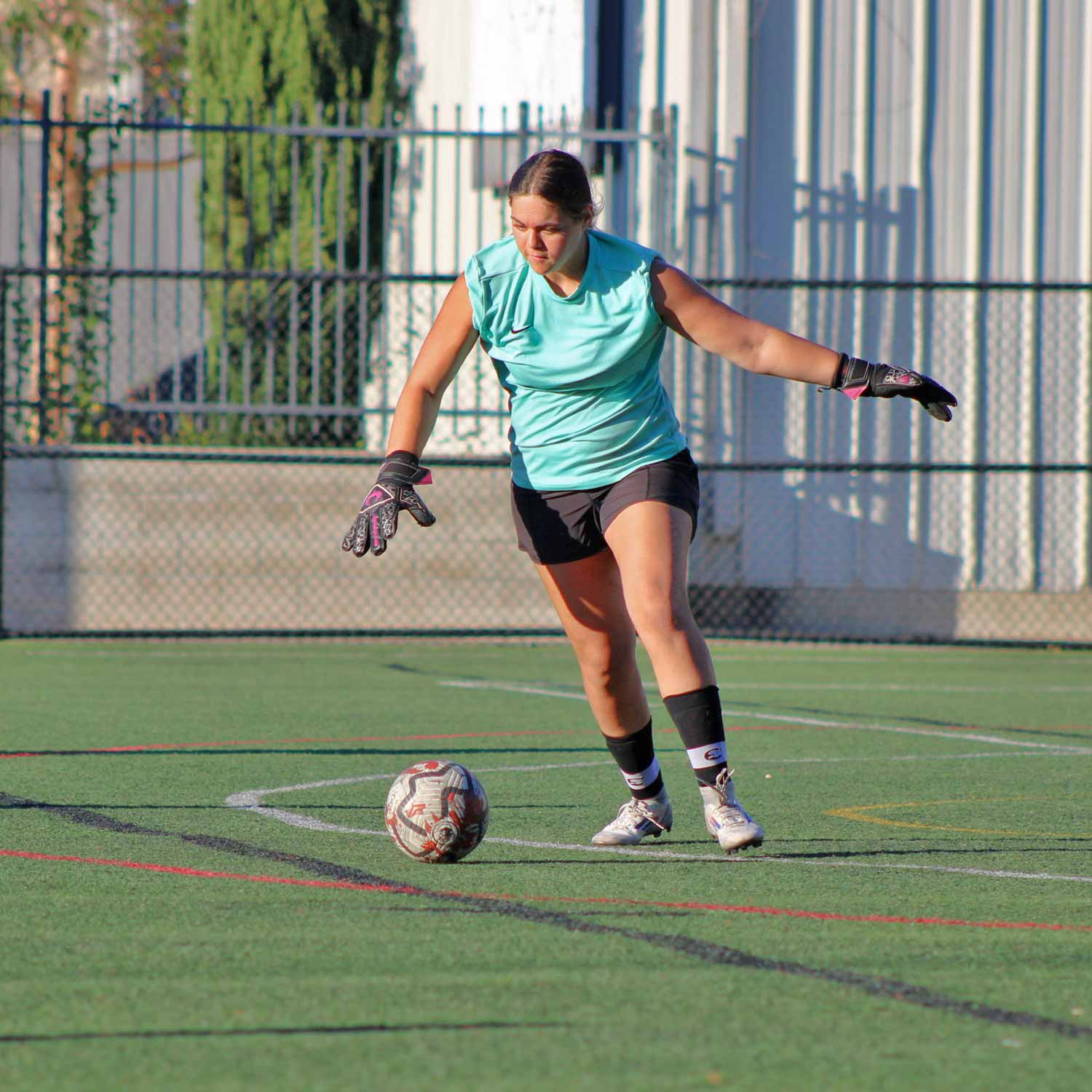Women's Soccer goalie about to kick a ball