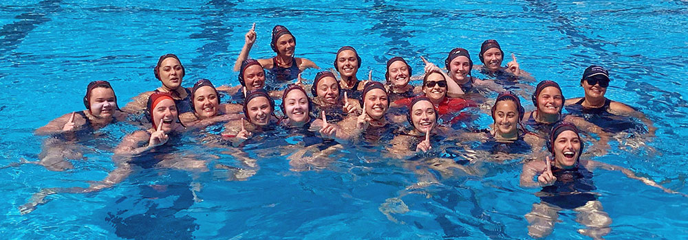 Women's Water Polo Club in the pool smiling