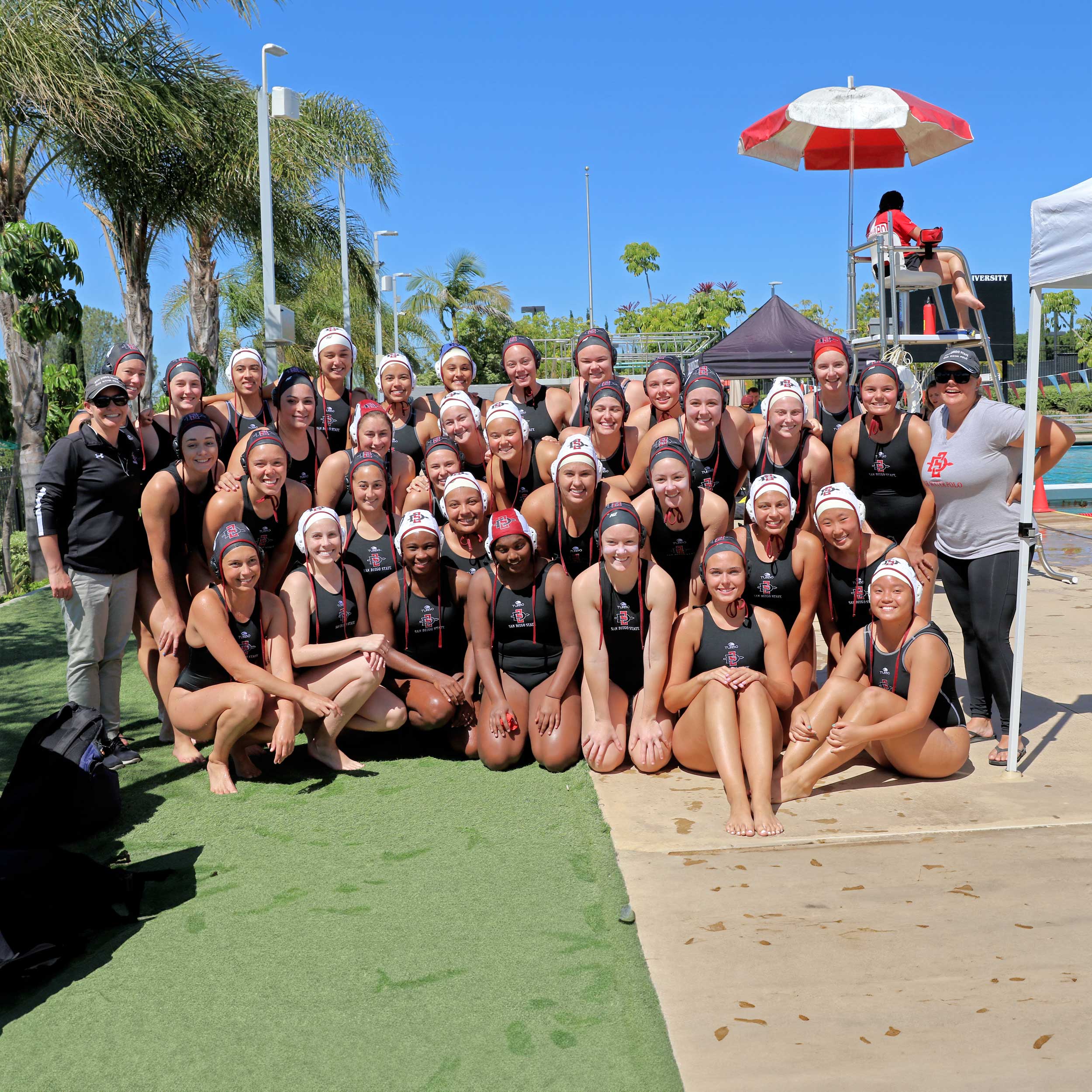 Group photo of the women's water polo club team members next to the pool