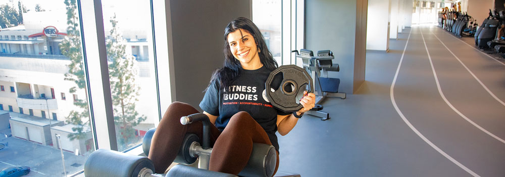 Smiling student using fitness equipment to do situps