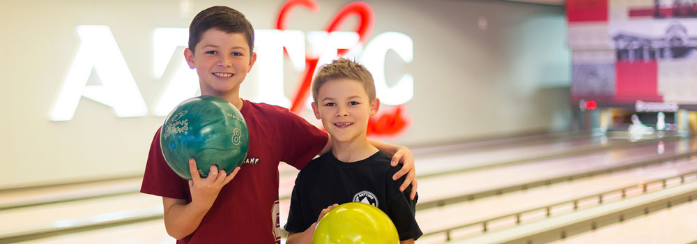 Two boys with bowling balls at Aztec Lanes